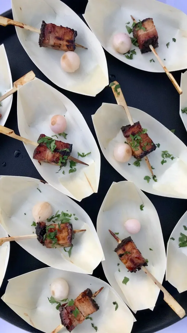 BRIKETT canapés served in paper boats at a catering event