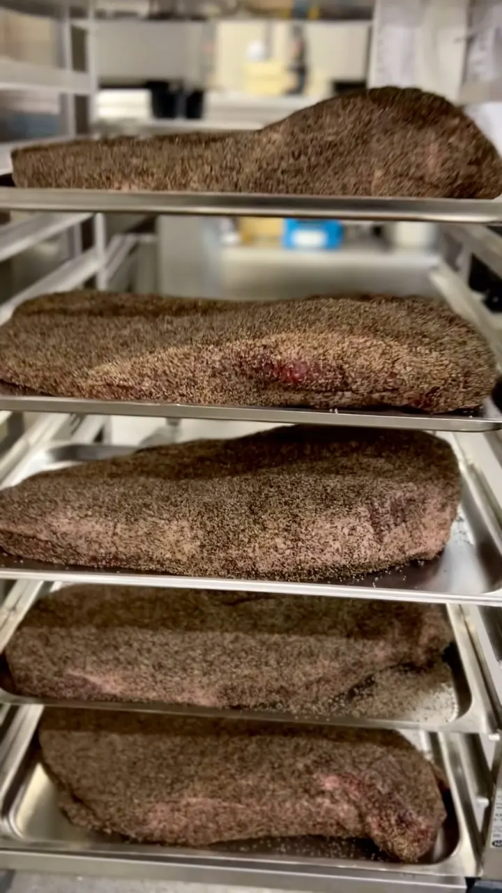 A rack full of rubbed briskets ready for the smoker